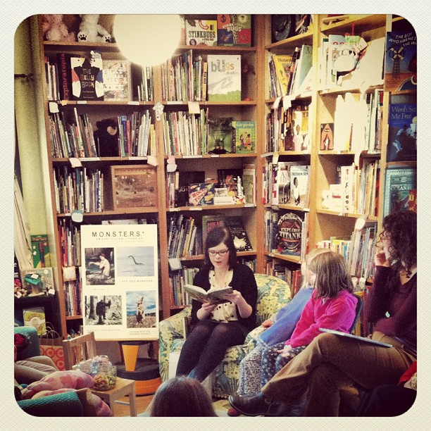 Emily reading aloud to children in a bookshop